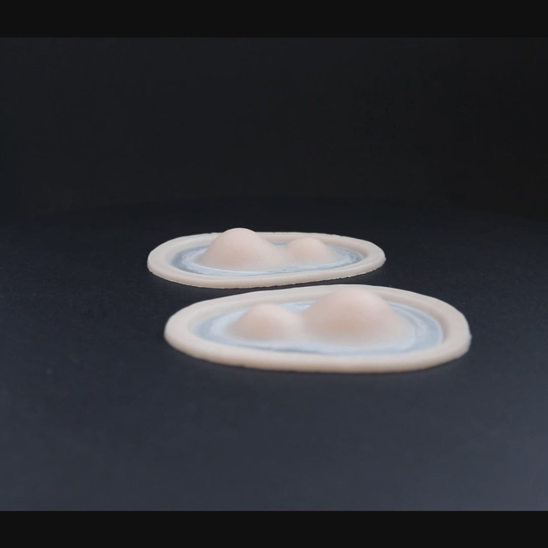 A pair of double subdermal horn prosthetics in vanilla shade on a black turntable, slowly rotating.
