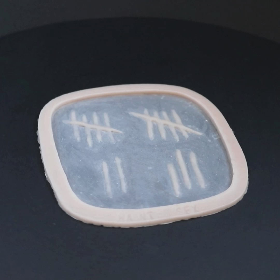 Tally mark prosthetic in vanilla shade on a black turntable, slowly rotating.