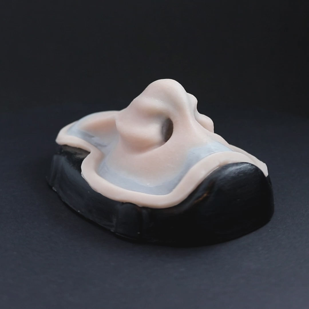 Whelk nose prosthetic in vanilla shade on a black turntable, slowly rotating.