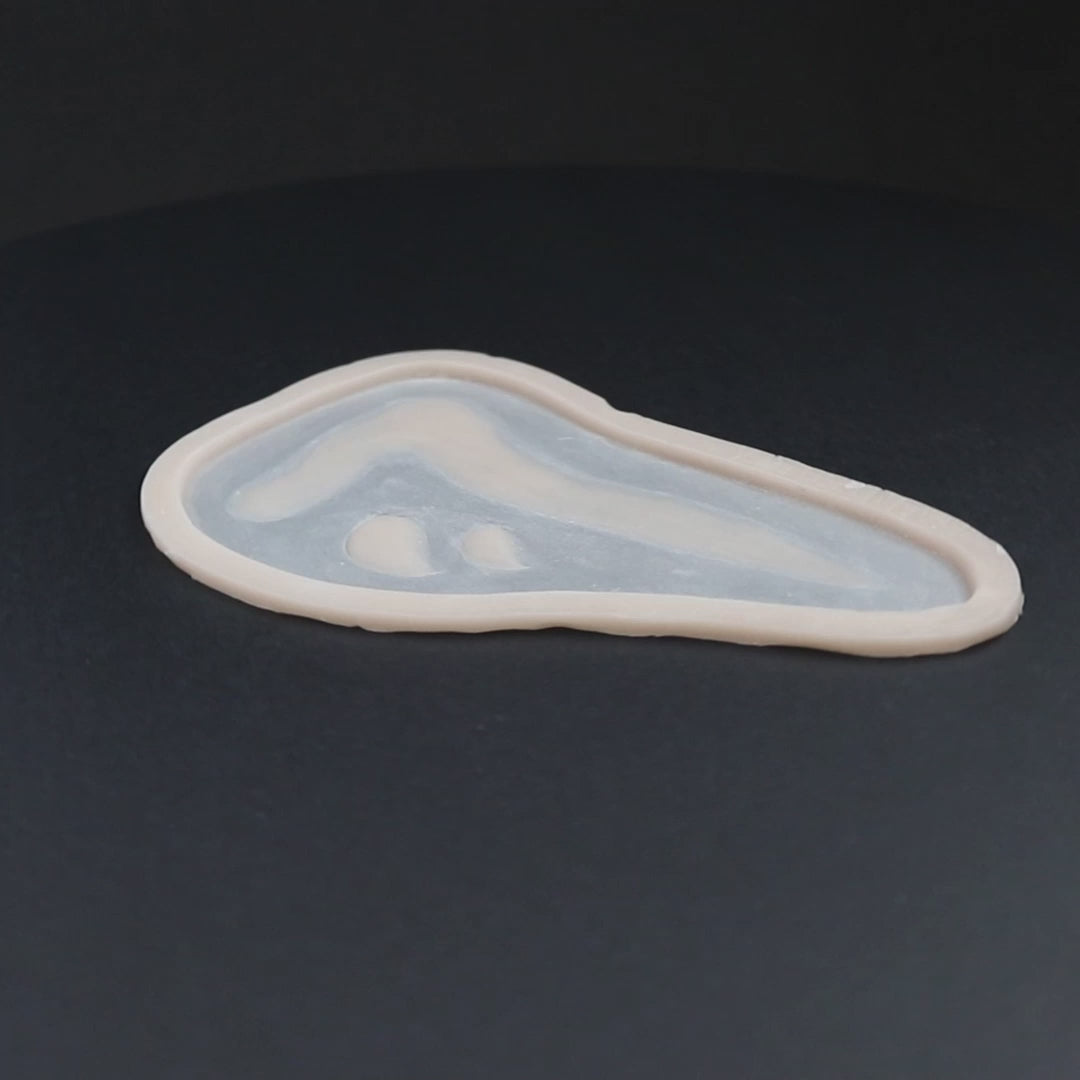 Mark of Cain prosthetic in vanilla shade on a black turntable, slowly rotating.