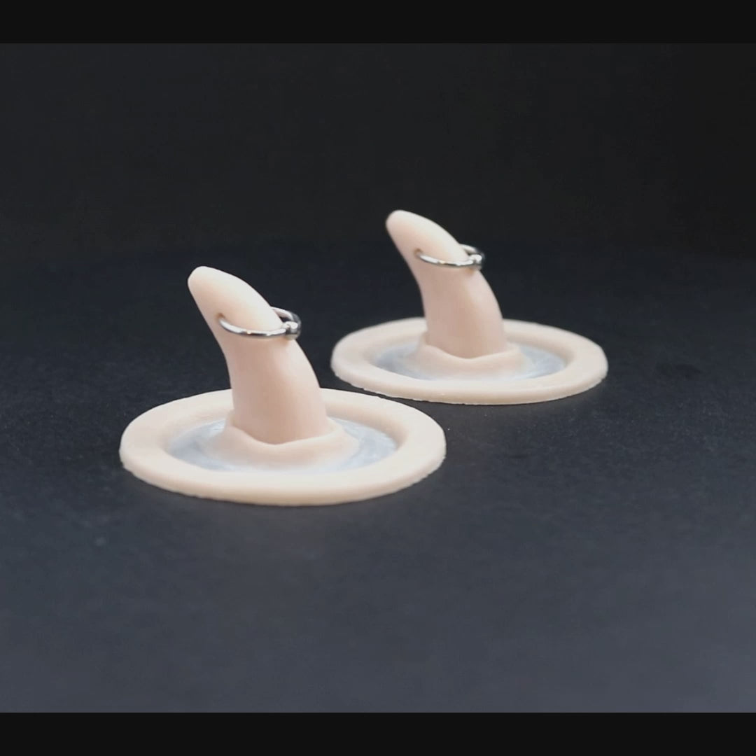 Pierced horns prosthetics in vanilla shade on a black turntable, slowly rotating.