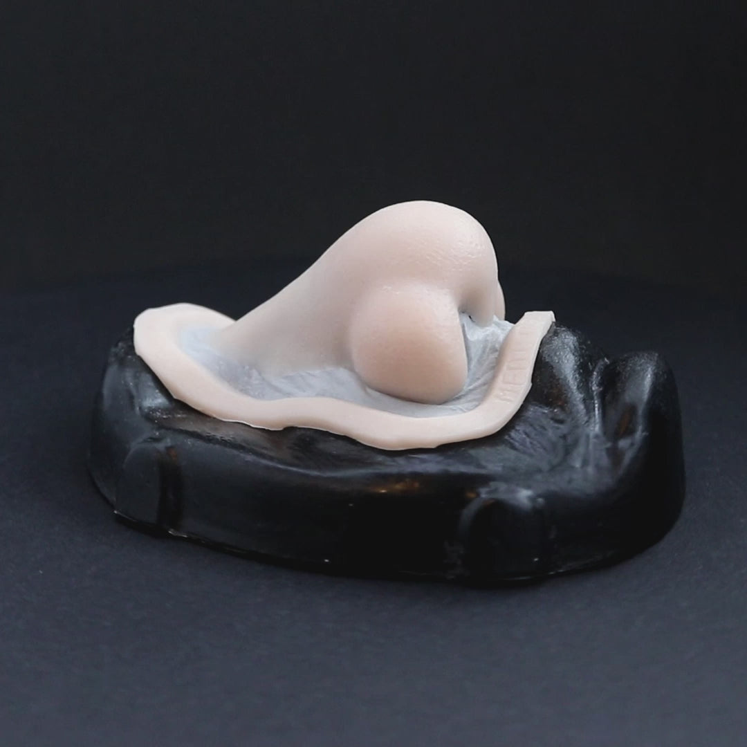 Troll nose prosthetic in vanilla shade on a black turntable, slowly rotating.