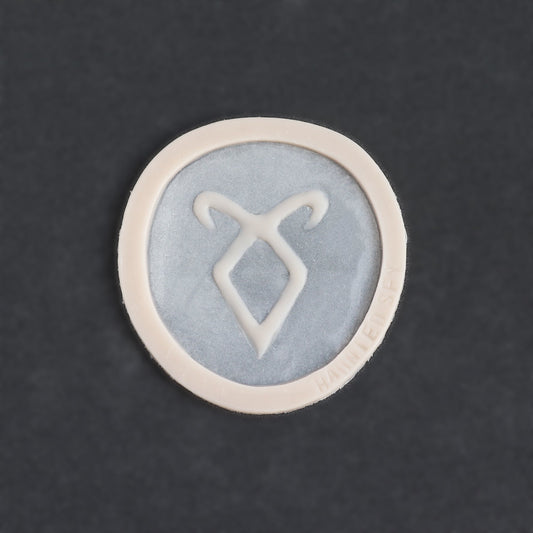 Angel Rune Scarification in vanilla shade on a black surface.