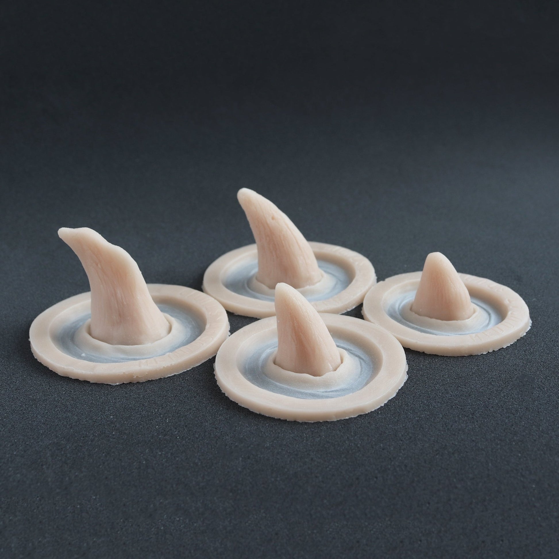 Four Crooked Horns - Silicone makeup prosthetic in vanilla shade on a black surface
