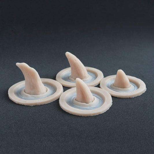 Four Crooked Horns - Silicone makeup prosthetic in vanilla shade on a black surface