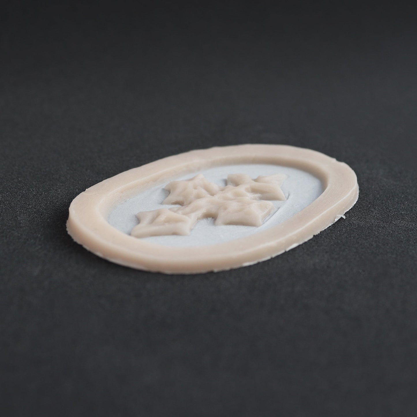 Facial Scales - Silicone makeup prosthetic in vanilla shade on a black surface