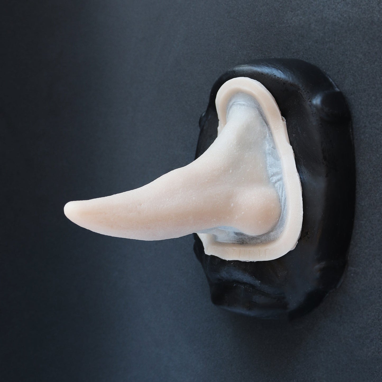 House Elf Nose - Silicone makeup prosthetic in vanilla shade on a black surface
