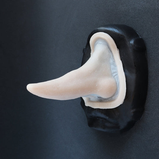 House Elf Nose - Silicone makeup prosthetic in vanilla shade on a black surface