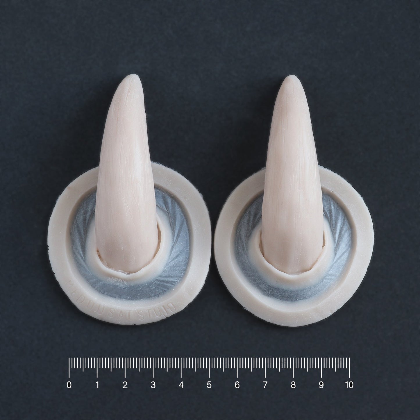 Oni Horns - Silicone makeup prosthetic in vanilla shade on a black surface with a ruler