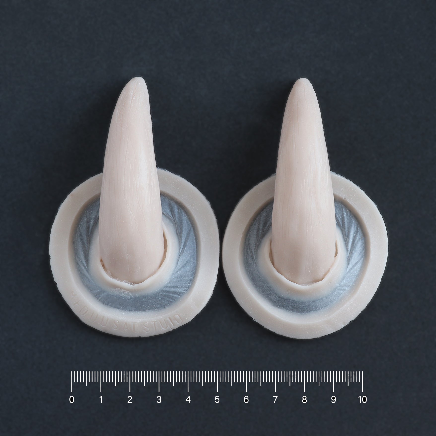 Oni Horns - Silicone makeup prosthetic in vanilla shade on a black surface with a ruler
