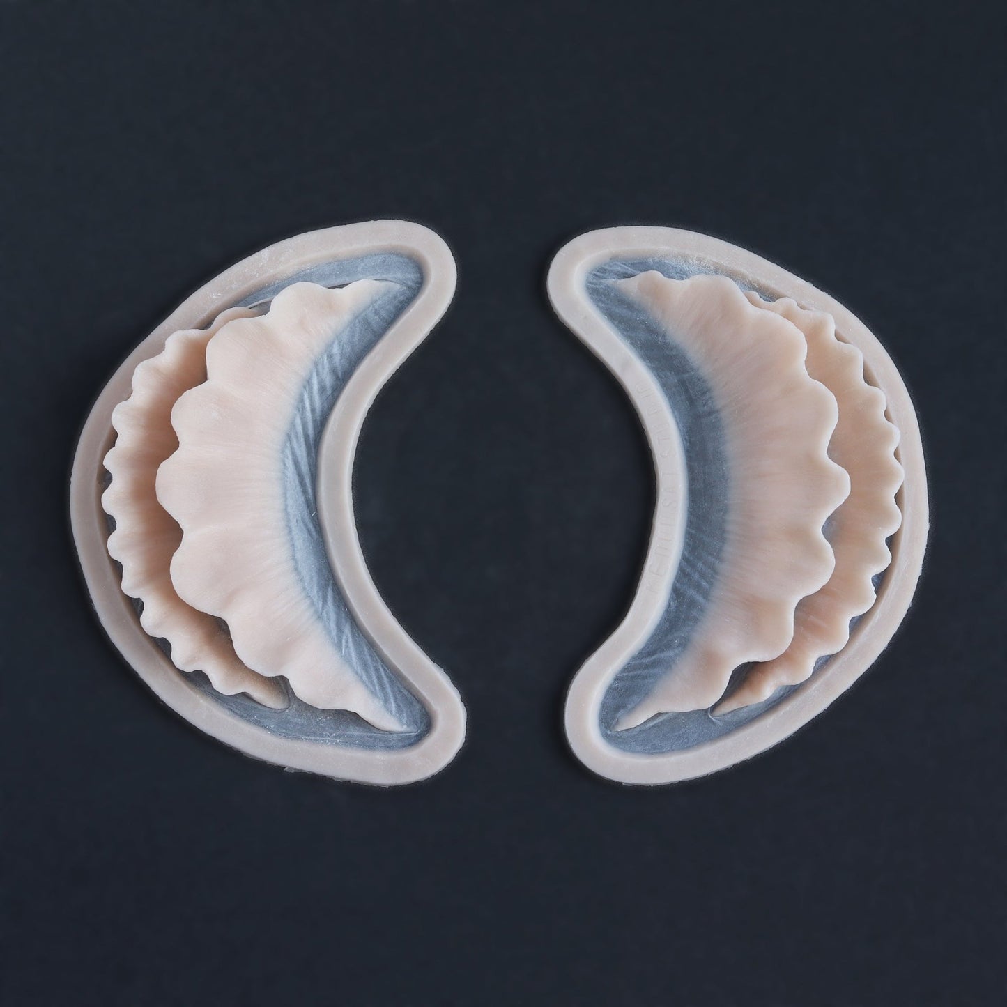 Ruffle Gills (Pair) - Silicone makeup prosthetic in vanilla shade on a black surface