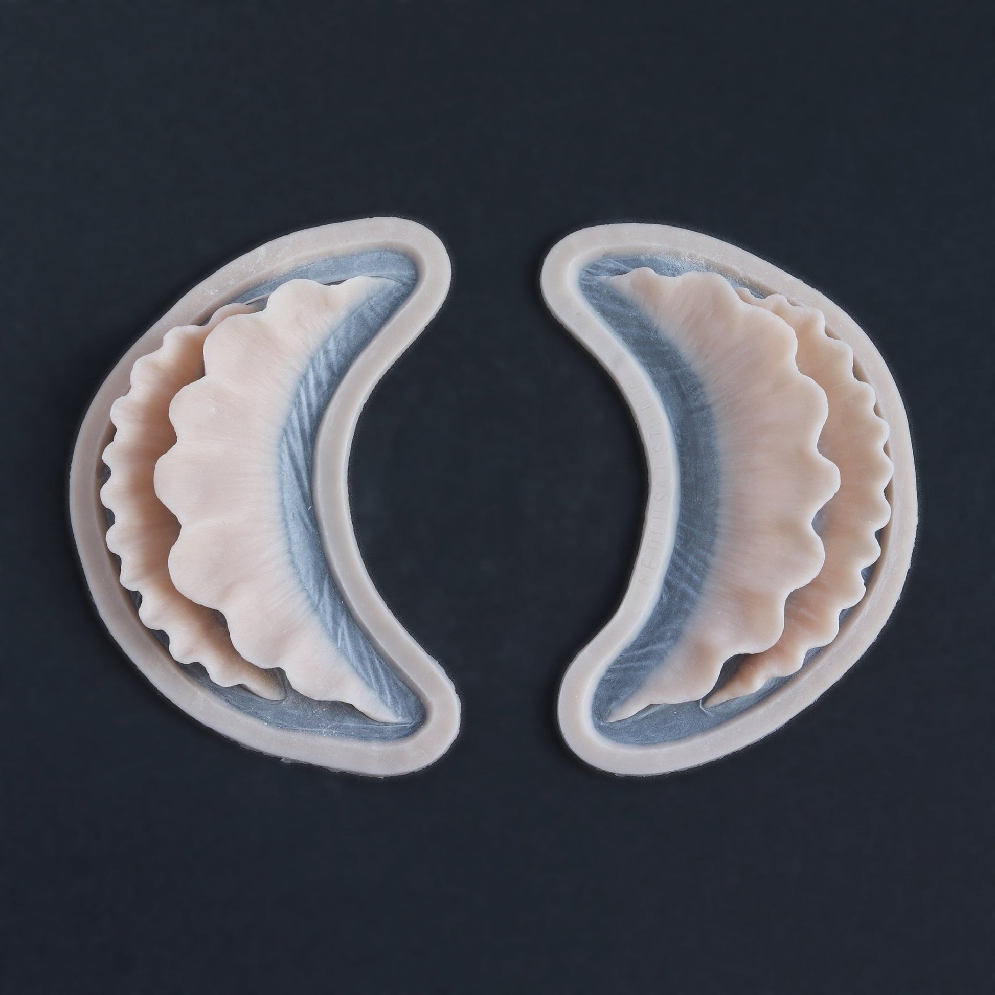 Ruffle Gills (Pair) - Silicone makeup prosthetic in vanilla shade on a black surface