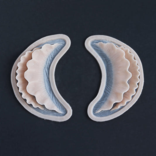 Ruffle Gills (Pair) - Silicone makeup prosthetic in vanilla shade on a black surface