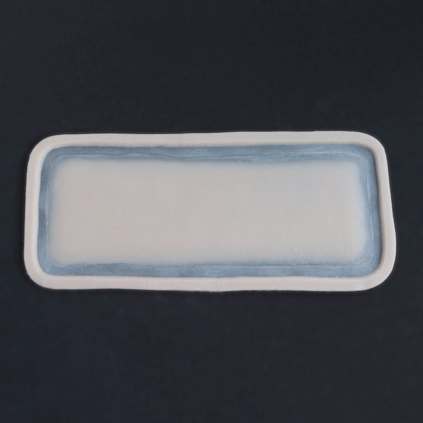 Long Silicone Patch - Silicone makeup prosthetic in vanilla shade on a black surface