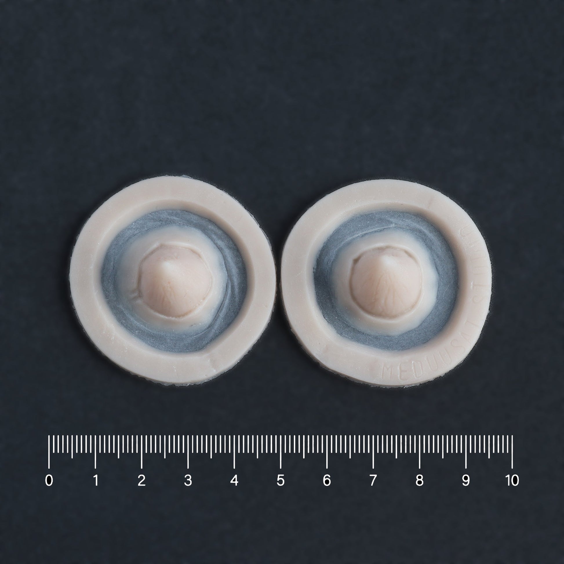 Small Devil Horns (Pair) - Silicone makeup prosthetic in vanilla shade on a black surface with a ruler