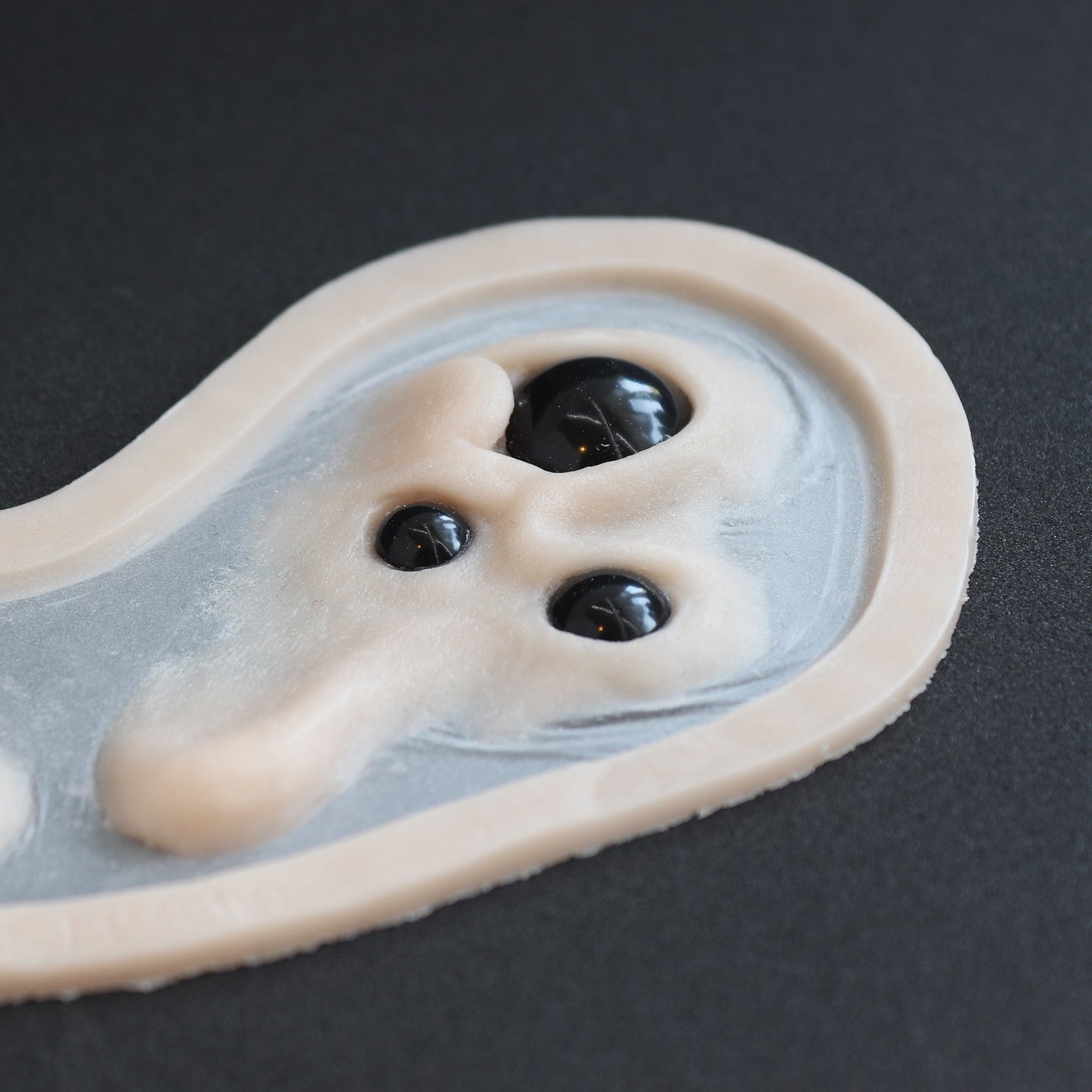 Spider Eyes - Silicone makeup prosthetic in vanilla shade on a black surface
