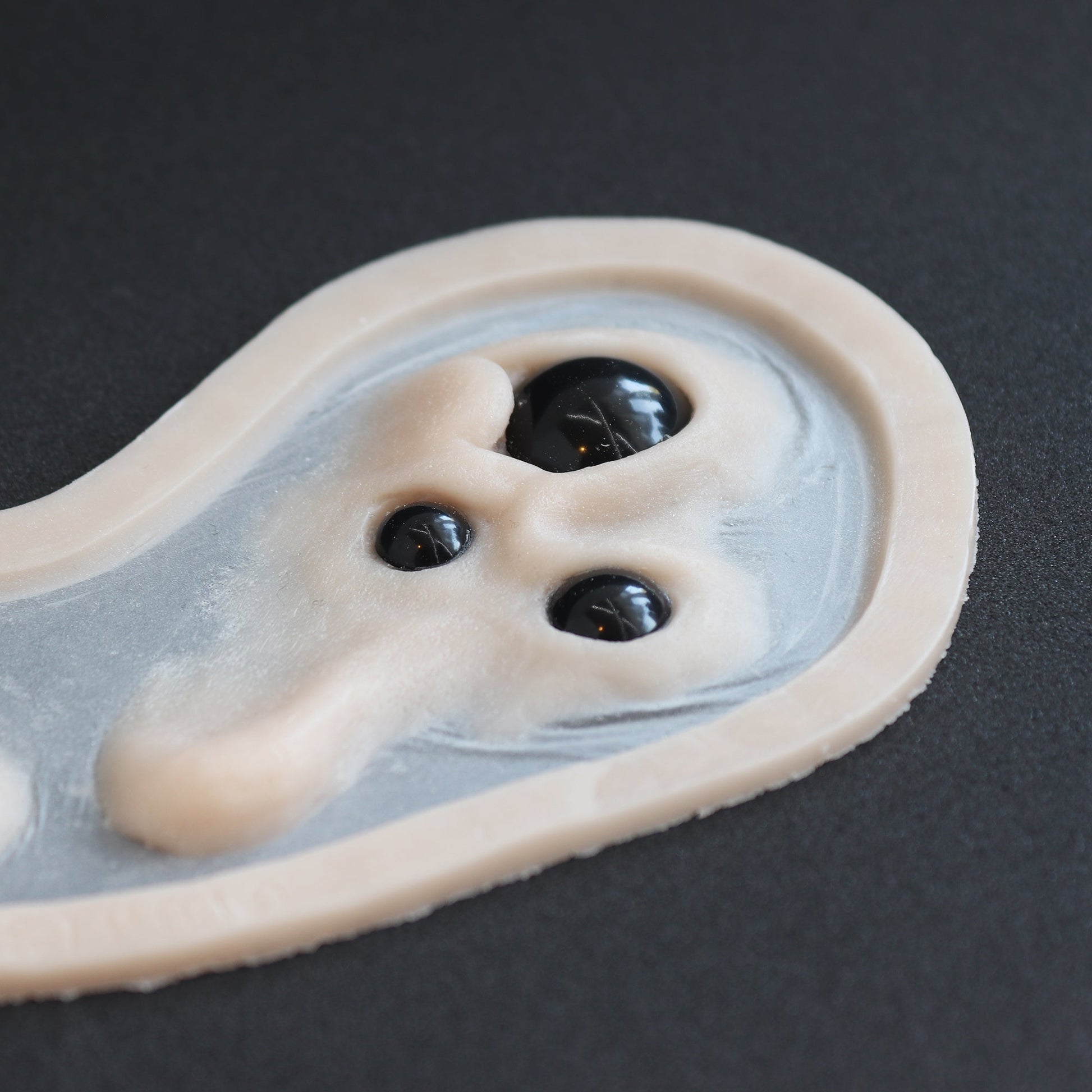 Spider Eyes - Silicone makeup prosthetic in vanilla shade on a black surface