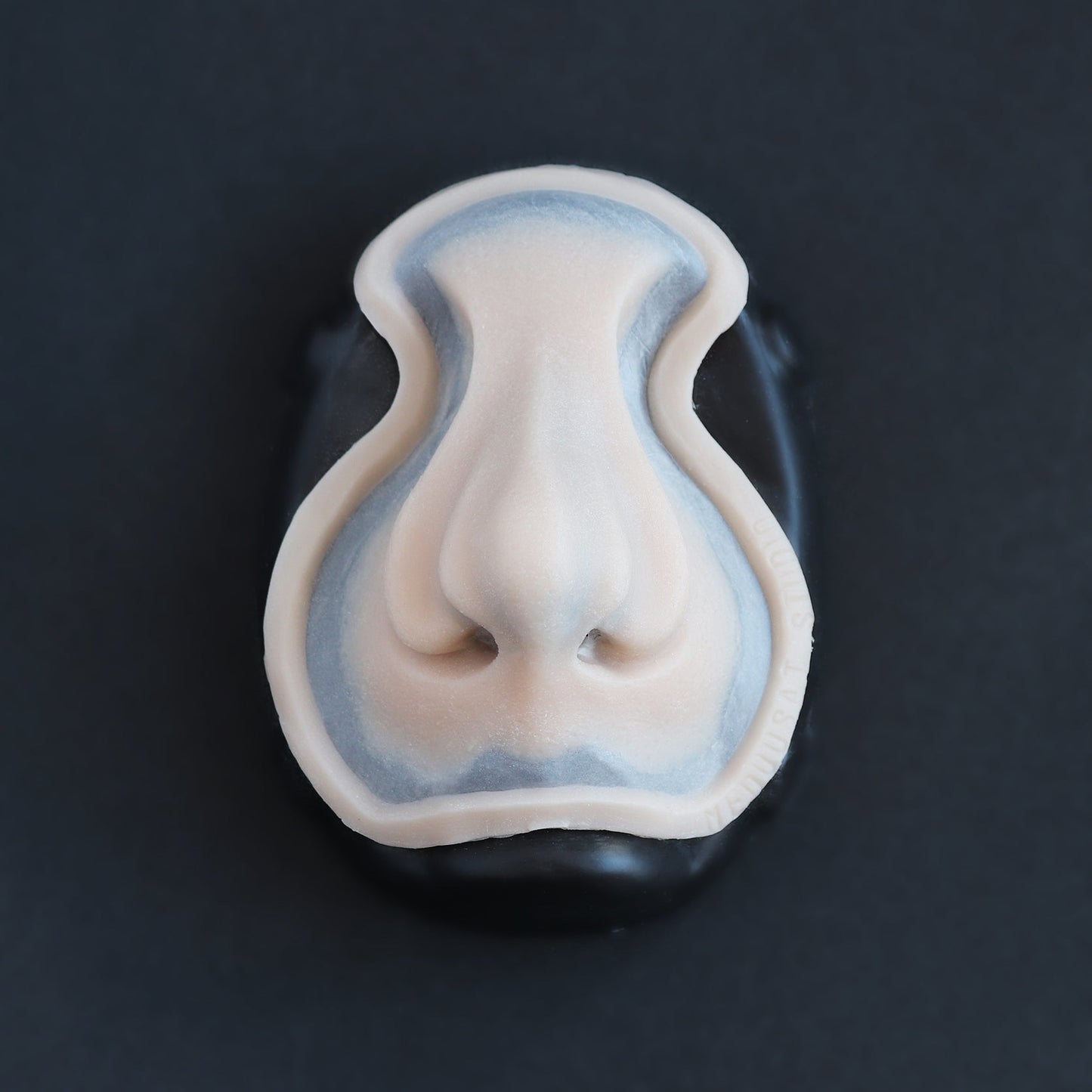 Whelk Nose - Silicone makeup prosthetic in vanilla shade on a black surface