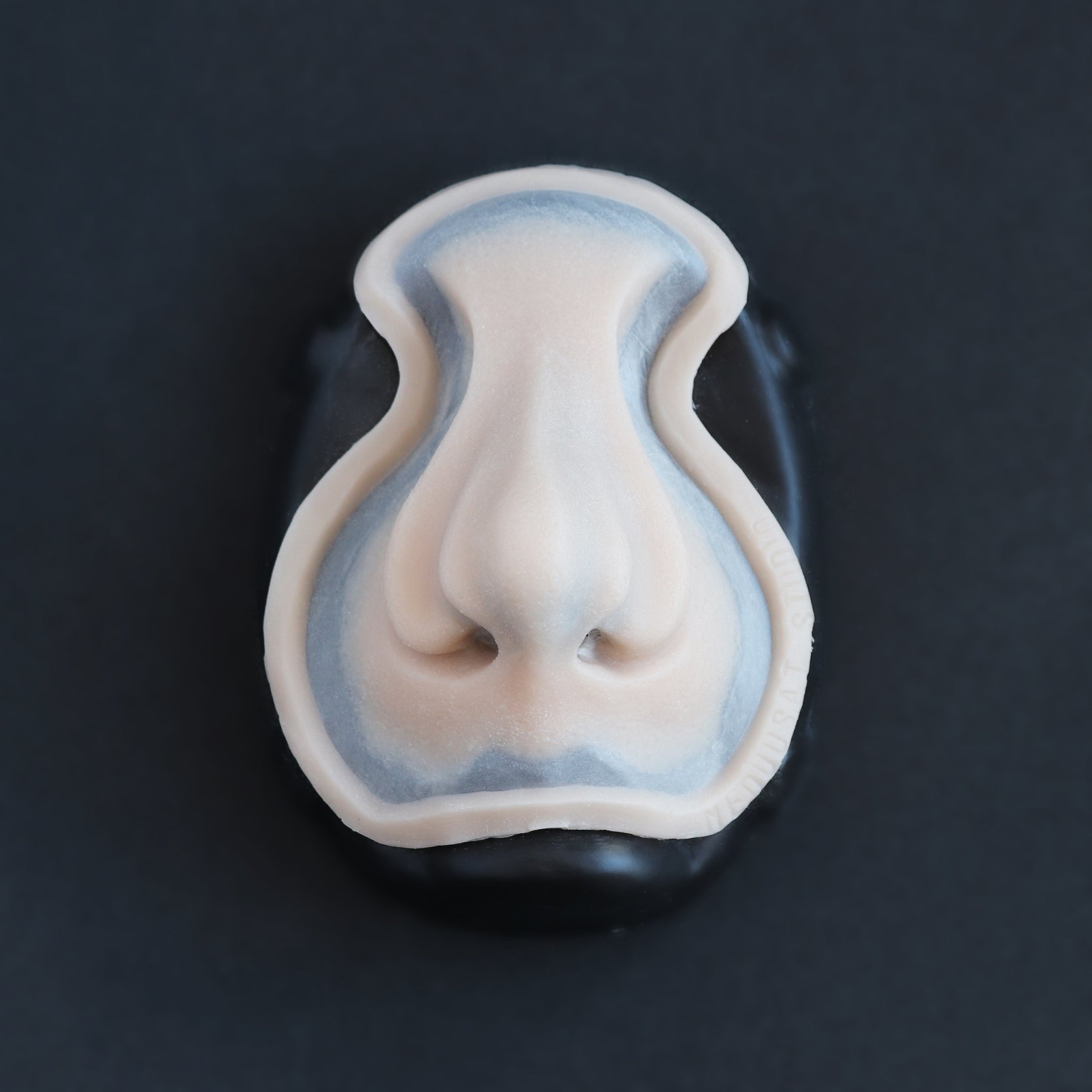 Whelk Nose - Silicone makeup prosthetic in vanilla shade on a black surface
