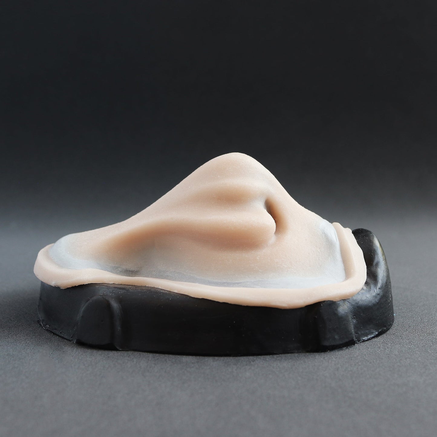 Whelk Nose - Silicone makeup prosthetic in vanilla shade on a black surface