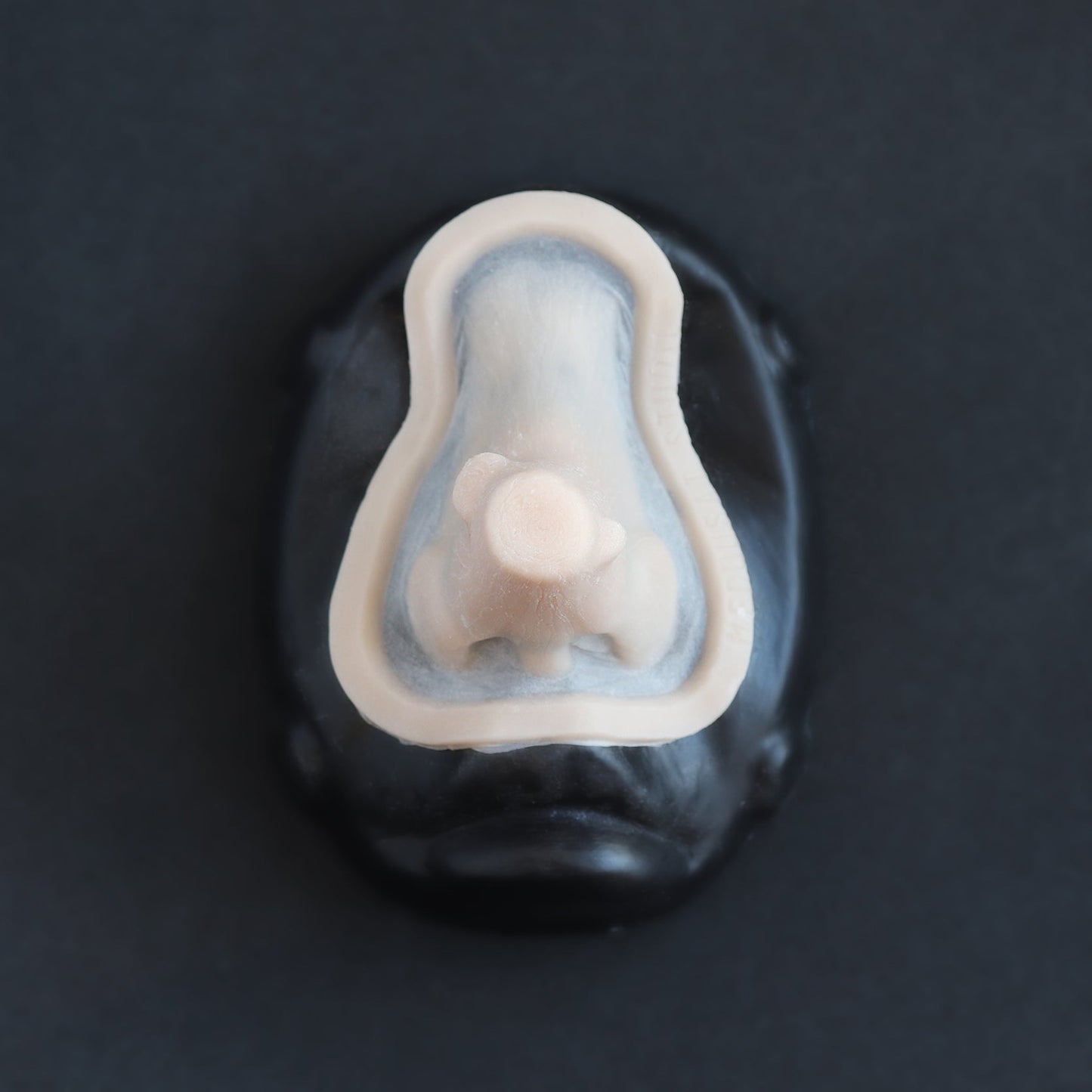 Wooden Nose - Silicone makeup prosthetic in vanilla shade on a black surface