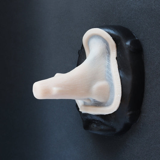 Wooden Nose - Silicone makeup prosthetic in vanilla shade on a black surface