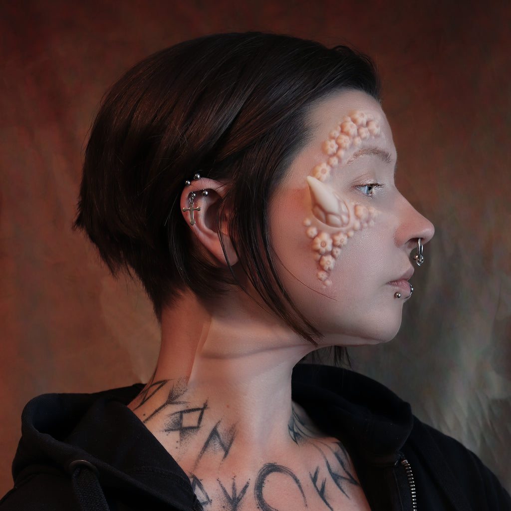 Woman with dark hair wearing jaw gills and barnacle face silicone makeup prosthetics