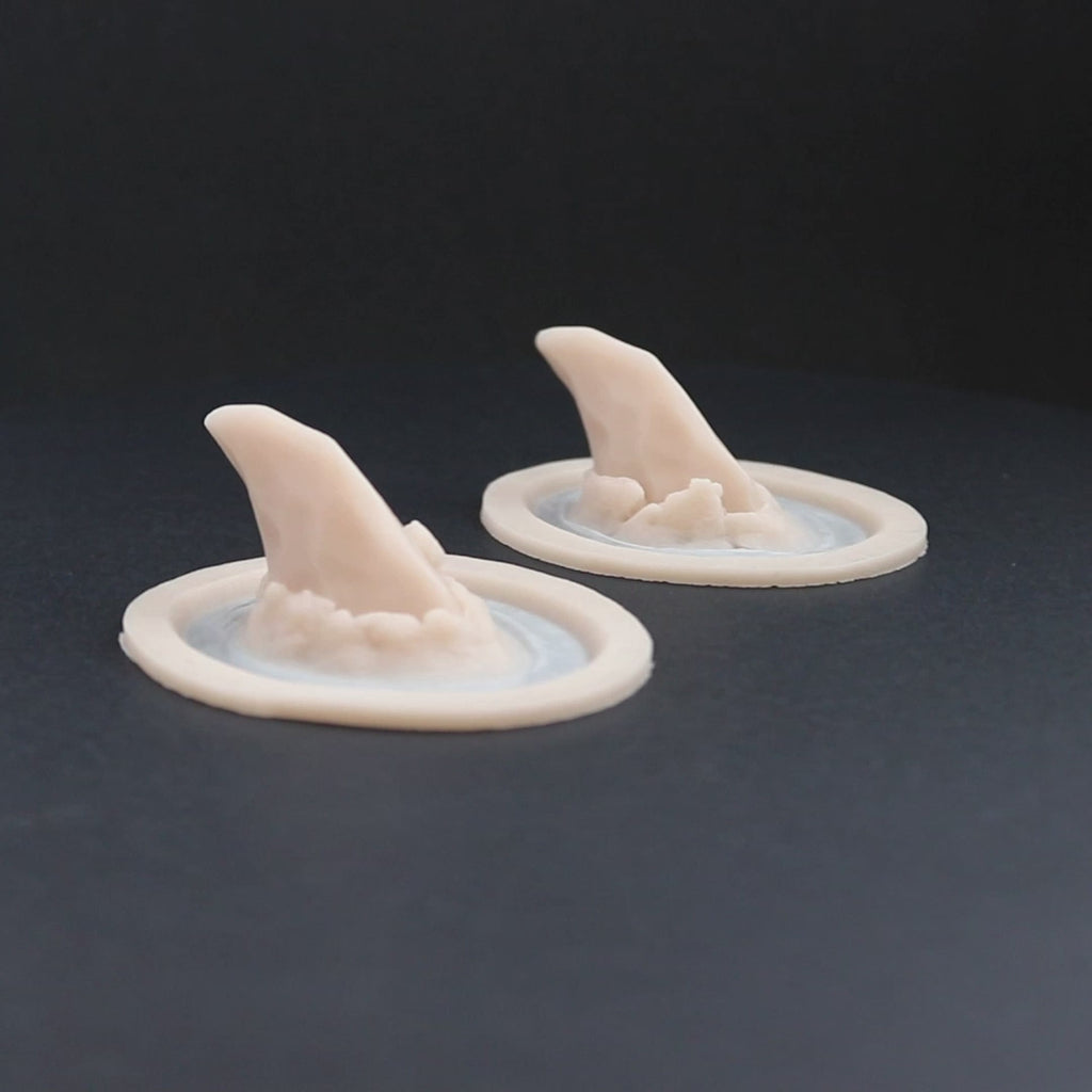 Pair of torn horns prosthetics in vanilla shade on a black turntable, slowly rotating. 