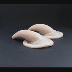 A pair of oni horns prosthetics in vanilla shade on a black turntable, slowly rotating. 