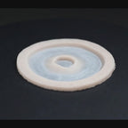 Gunshot Entry Wound prosthetic in vanilla shade on a black turntable, slowly rotating. 