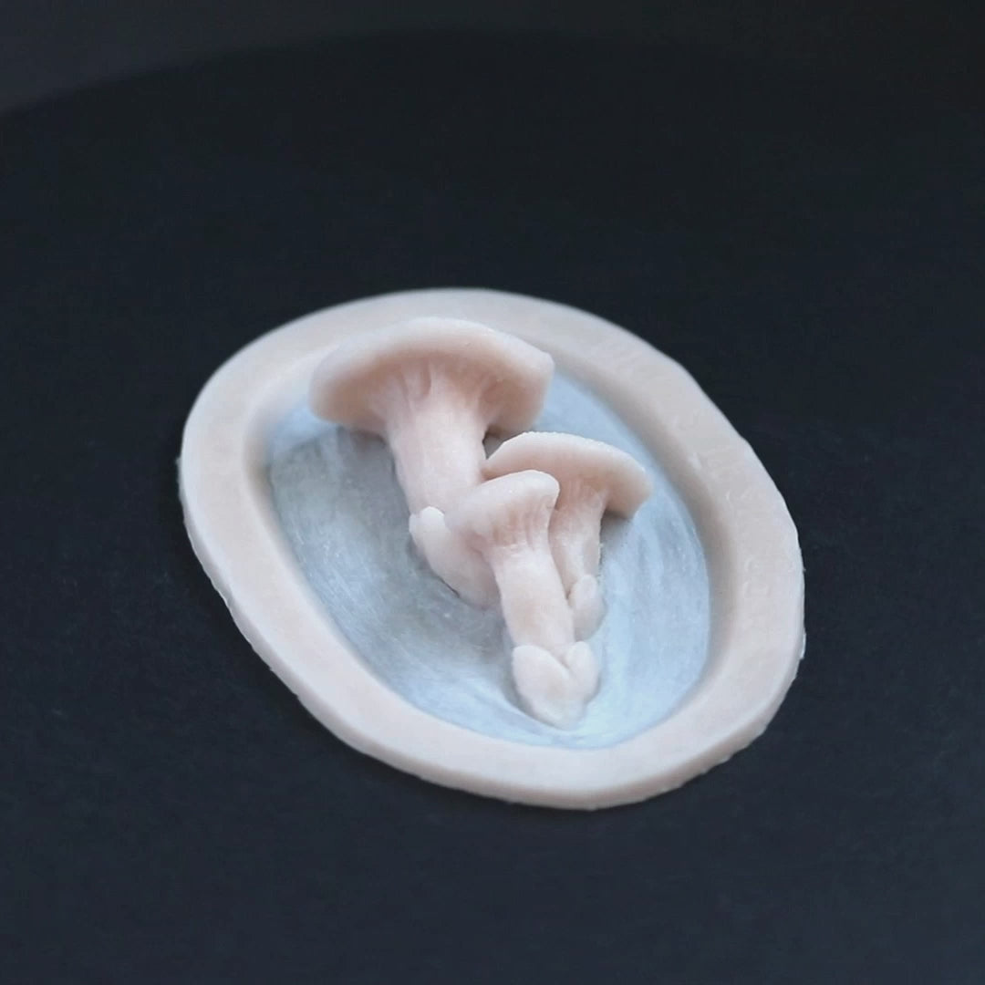 Fungi prosthetic in vanilla shade on a black turntable, slowly rotating. 