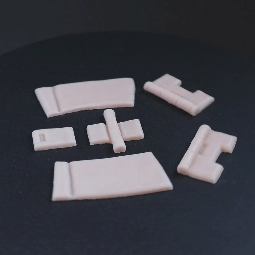 Silicone hinges in vanilla shade on a black turntable, slowly rotating. 