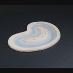 Half bite prosthetic in vanilla shade on a black turntable, slowly rotating. 