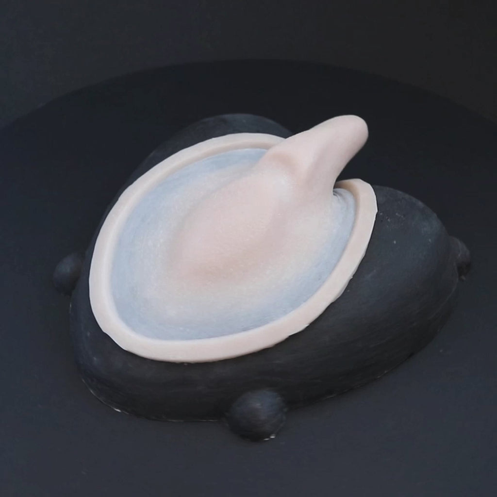 Demon Tail prosthetic in vanilla shade on a black turntable, slowly rotating. 