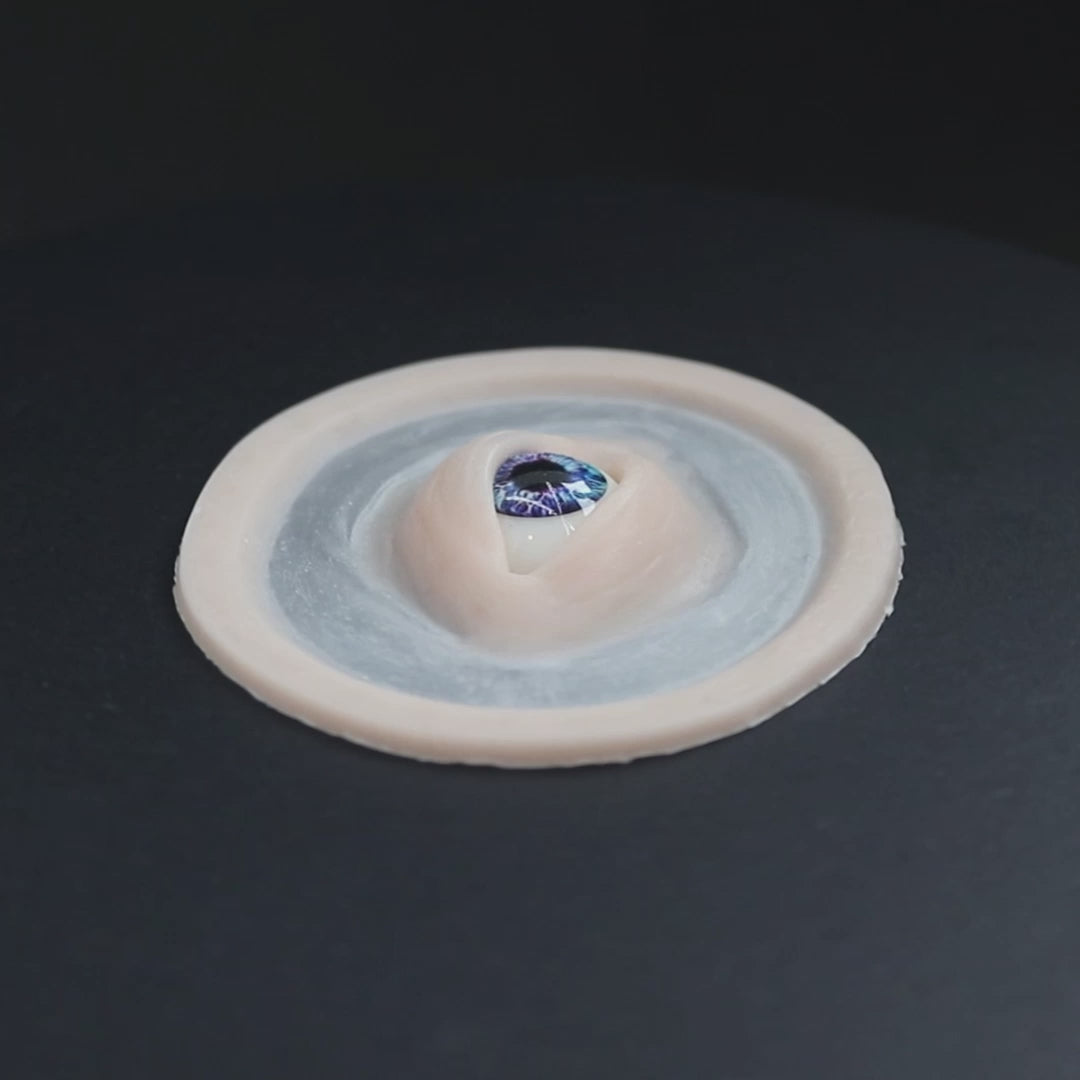 Galaxy Third Eye prosthetic in vanilla shade on a black turntable, slowly rotating. 