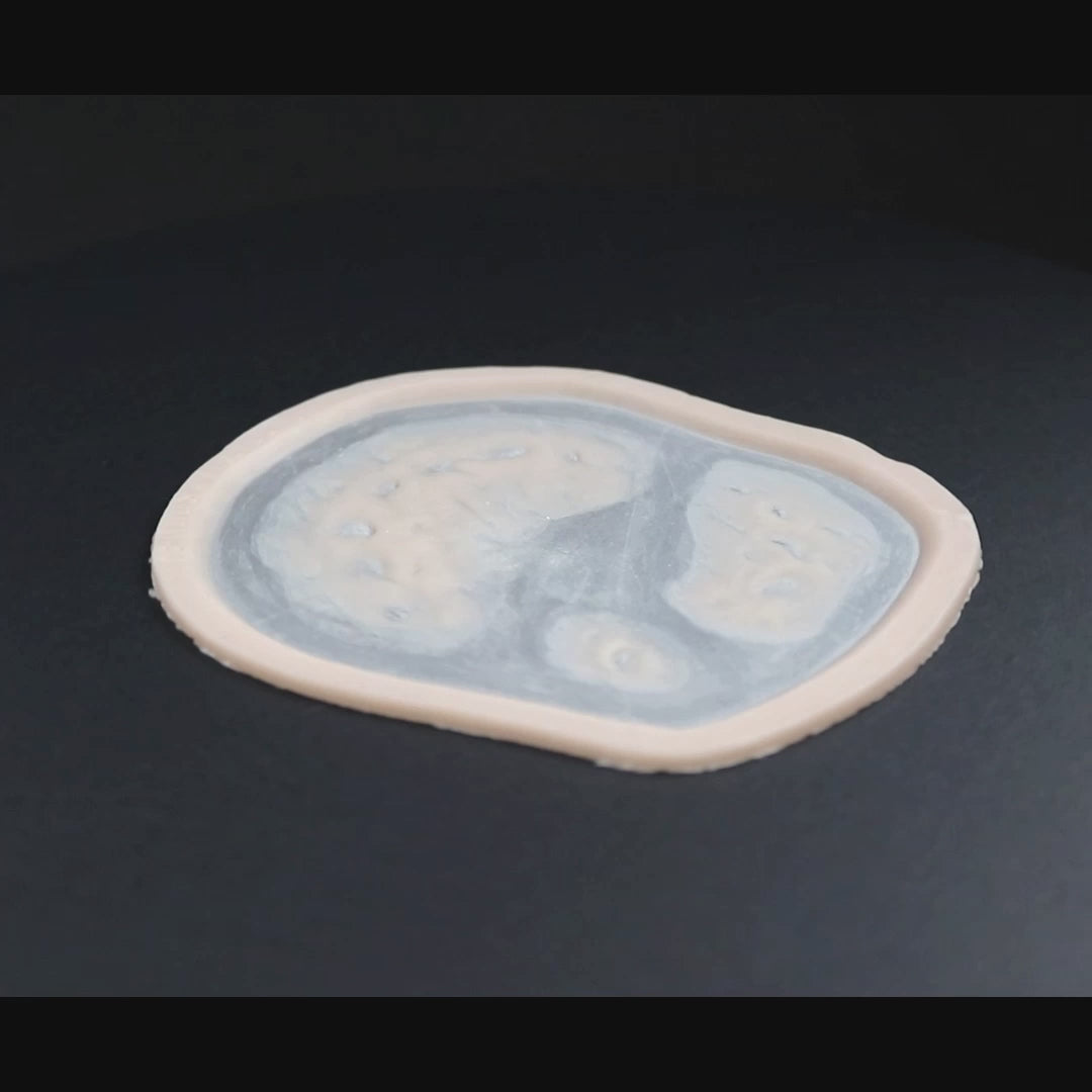 Zombie bite 2.0 prosthetic in vanilla shade on a black turntable, slowly rotating. 