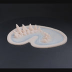 A dragon face prosthetic in vanilla shade on a black turntable, slowly rotating. 