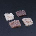 Four pieces of silicone in different skin tones on a black turntable, slowly rotating. 