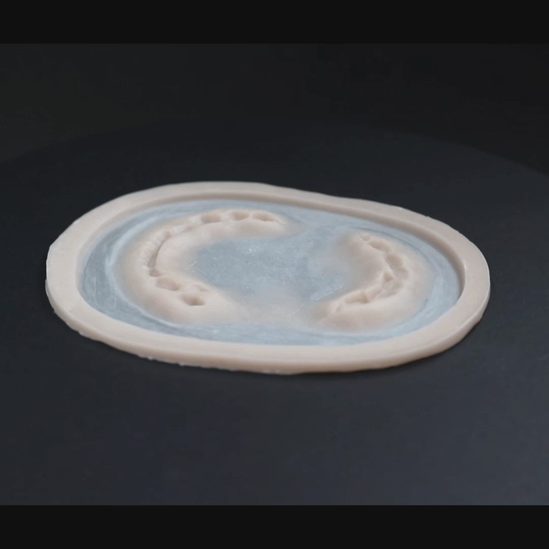 Zombie bite prosthetic in vanilla shade on a black turntable, slowly rotating. 