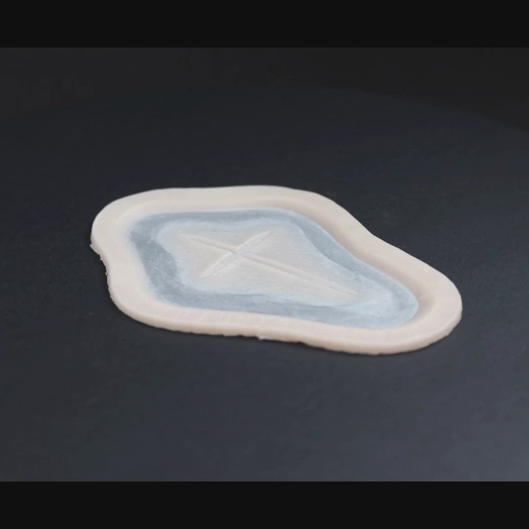 Cross Carving prosthetic in vanilla shade on a black turntable, slowly rotating. 