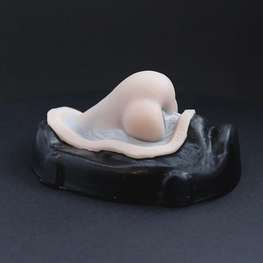 Troll nose prosthetic in vanilla shade on a black turntable, slowly rotating. 