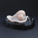 Troll nose prosthetic in vanilla shade on a black turntable, slowly rotating. 