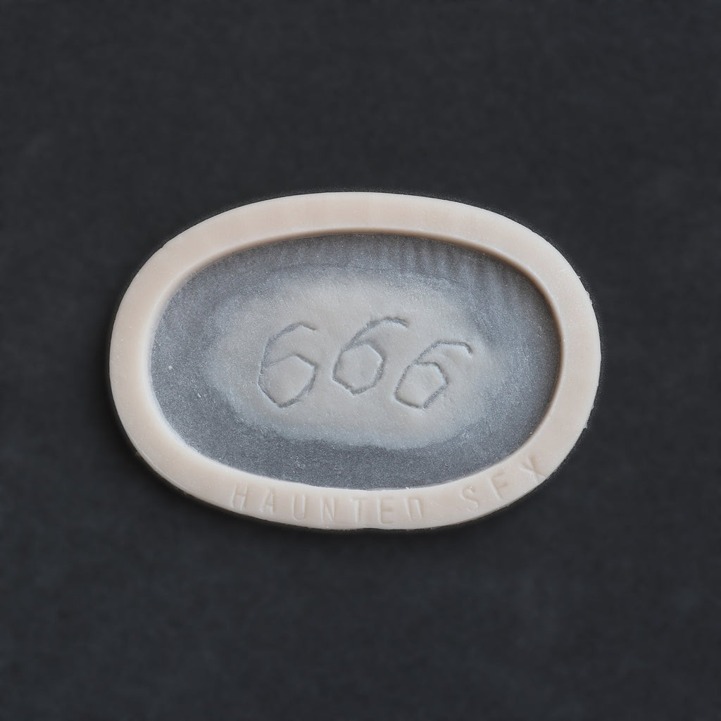 666 carving prosthetic in vanilla shade on a black surface
