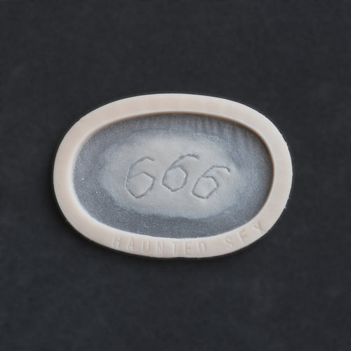 666 carving prosthetic in vanilla shade on a black surface