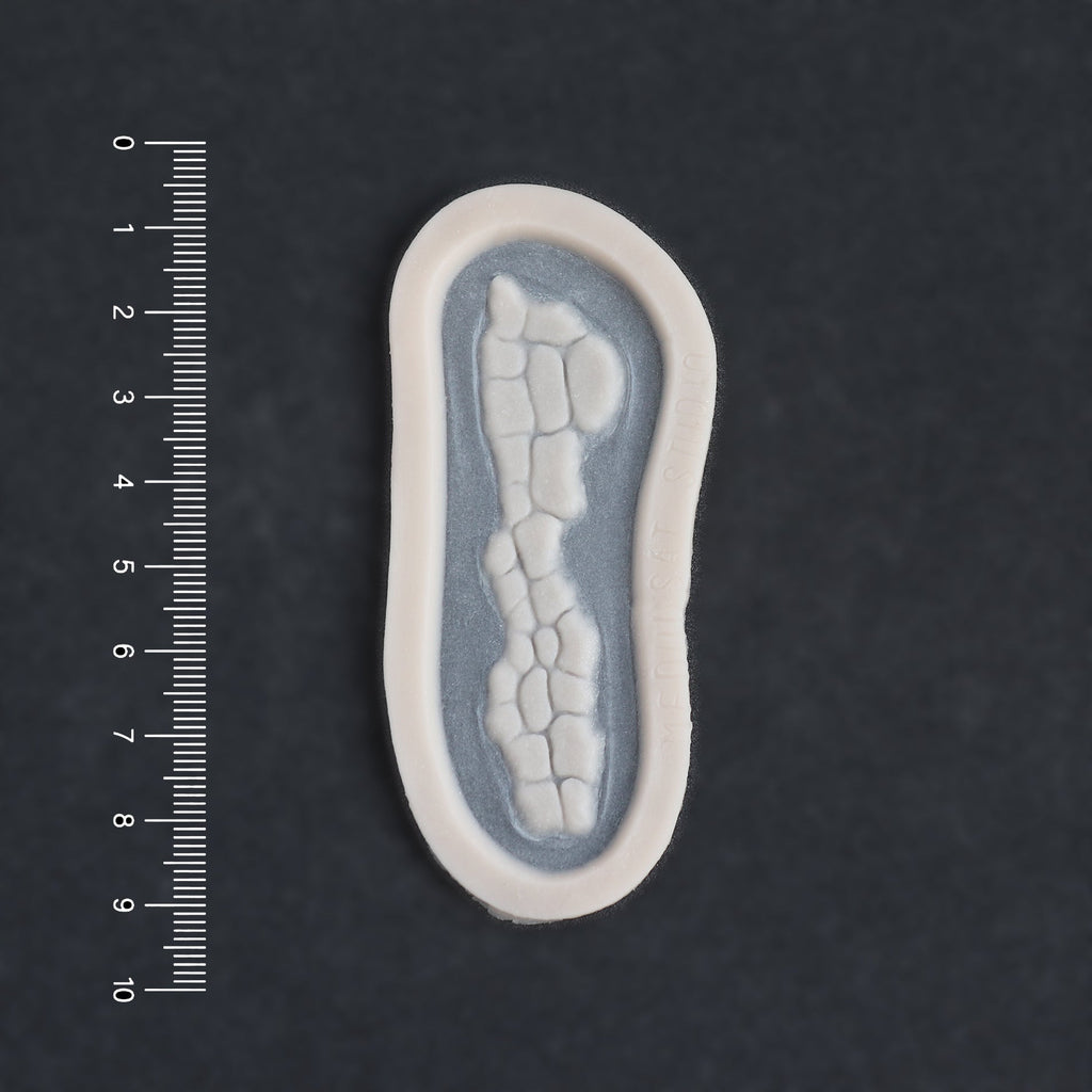 Alligator Scales nose piece in vanilla shade on a black surface with a ruler.