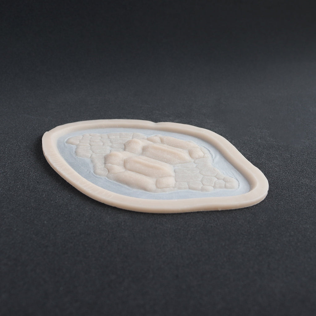 Alligator Scales neck piece in vanilla shade at an angle on a black surface.