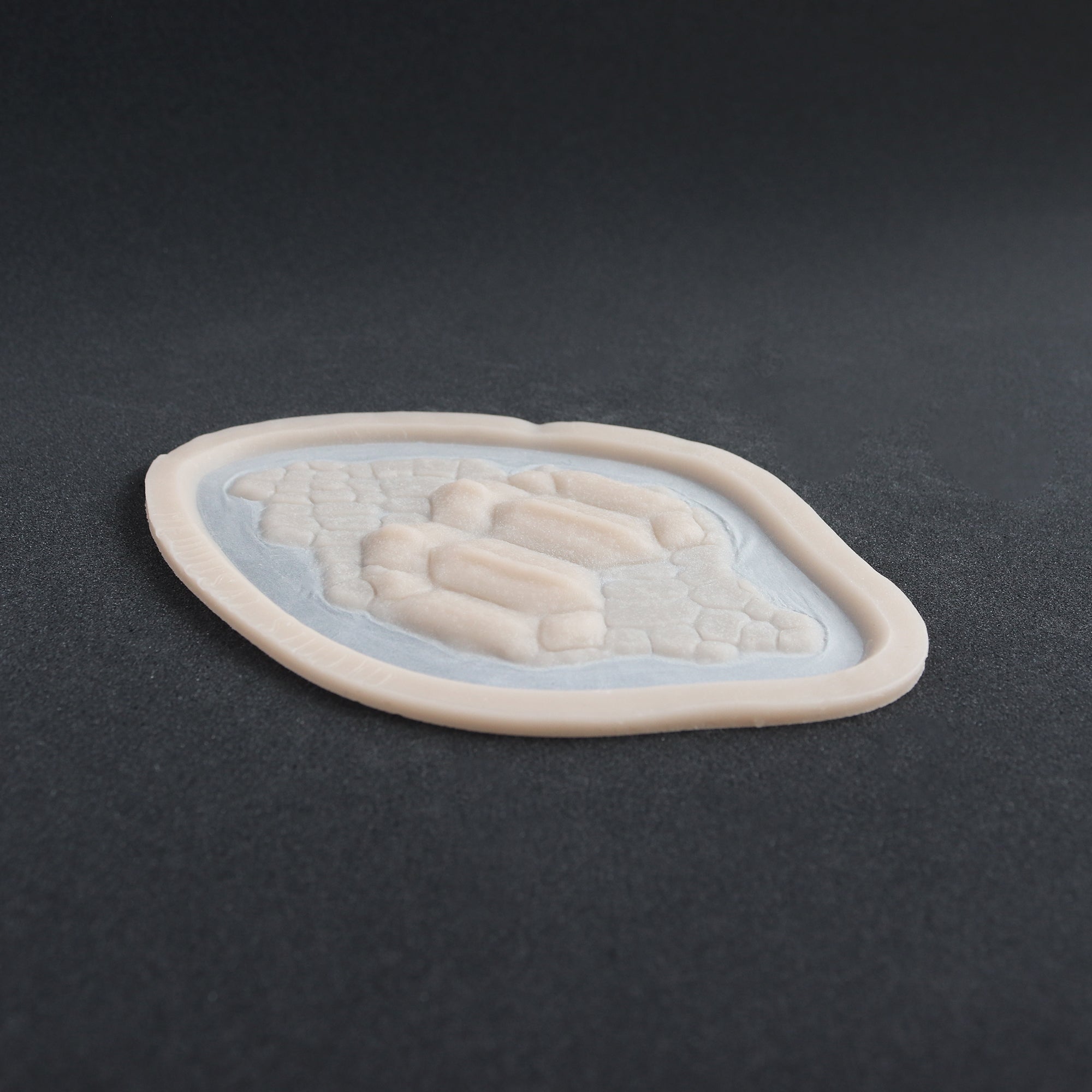 Alligator Scales neck piece in vanilla shade at an angle on a black surface.