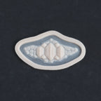 Alligator Scales chin piece in vanilla shade on a black surface.