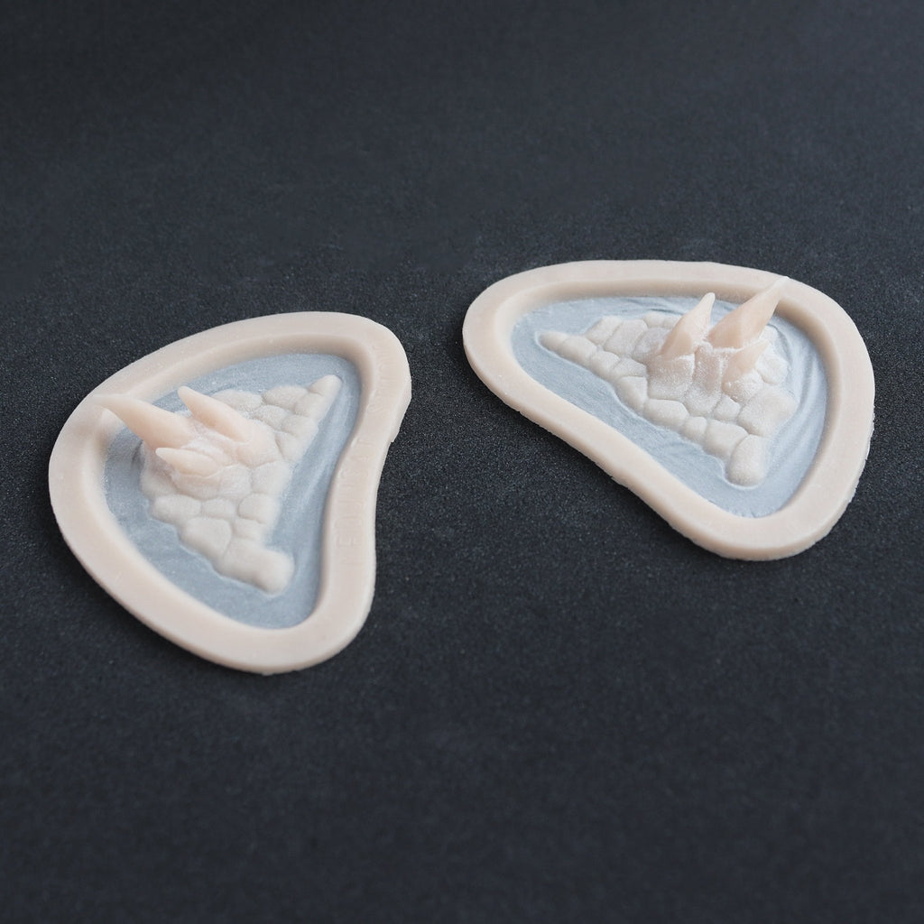 Alligator Scales temples in vanilla shade at an angle on a black surface.