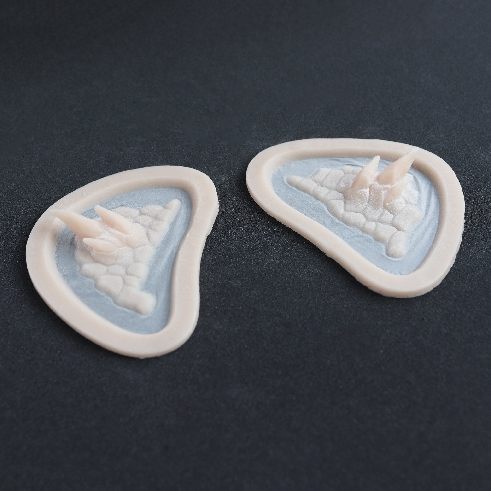 Alligator Scales temples in vanilla shade at an angle on a black surface.